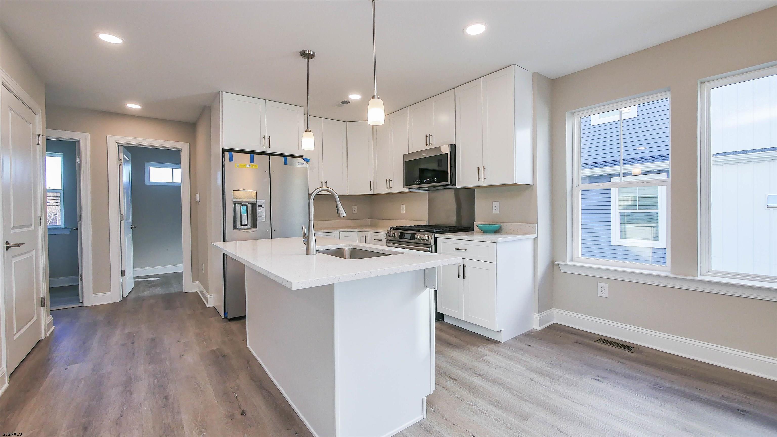 539 Sunset Avenue Somers Point, NJ 08244 - Photo 6 of 34 a kitchen with white cabinets and stainless steel appliances