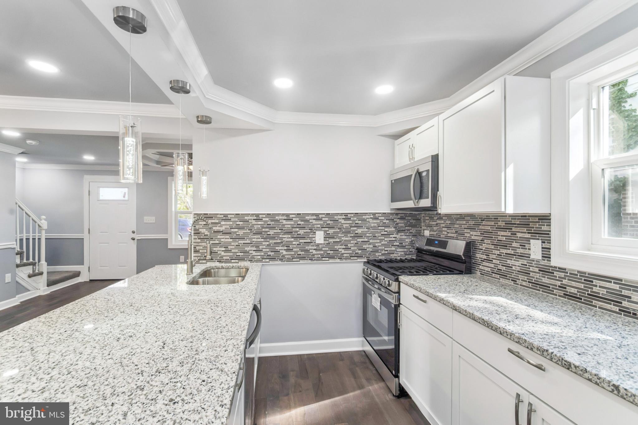 6804 Carol Road Baltimore, MD 21207 - Photo 6 of 25 a kitchen with a sink stove and cabinets