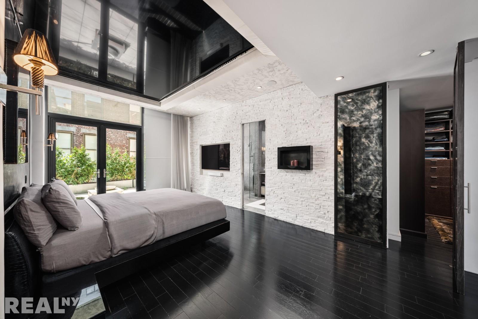 15 Union Square West, Unit 7C Manhattan, NY 10003 - Photo 5 of 18 a bedroom with a large bed a flat tv screen and a walk in closet