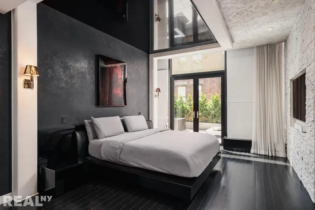 a bedroom with a bed next to a window