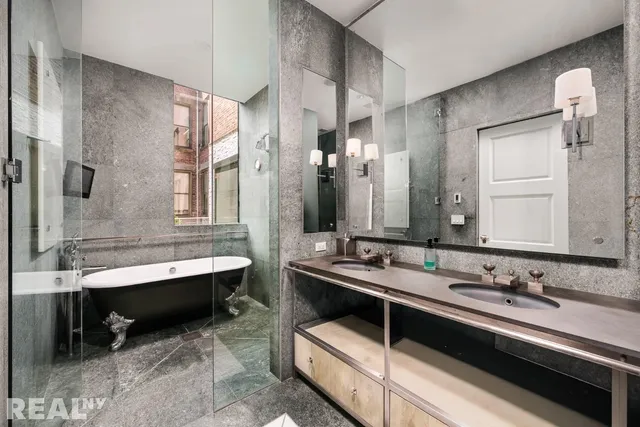 a bathroom with a tub sink and mirror