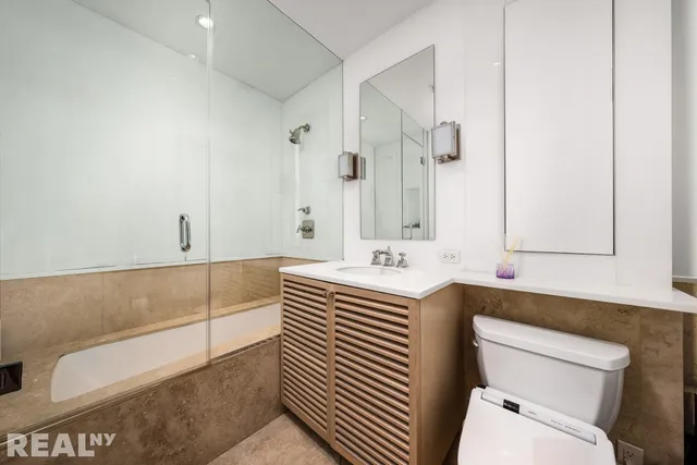 a bathroom with a sink a toilet and a mirror