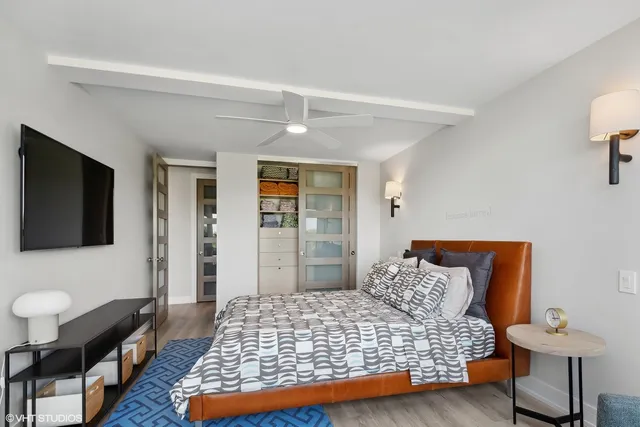 a bedroom with bed and flat screen tv