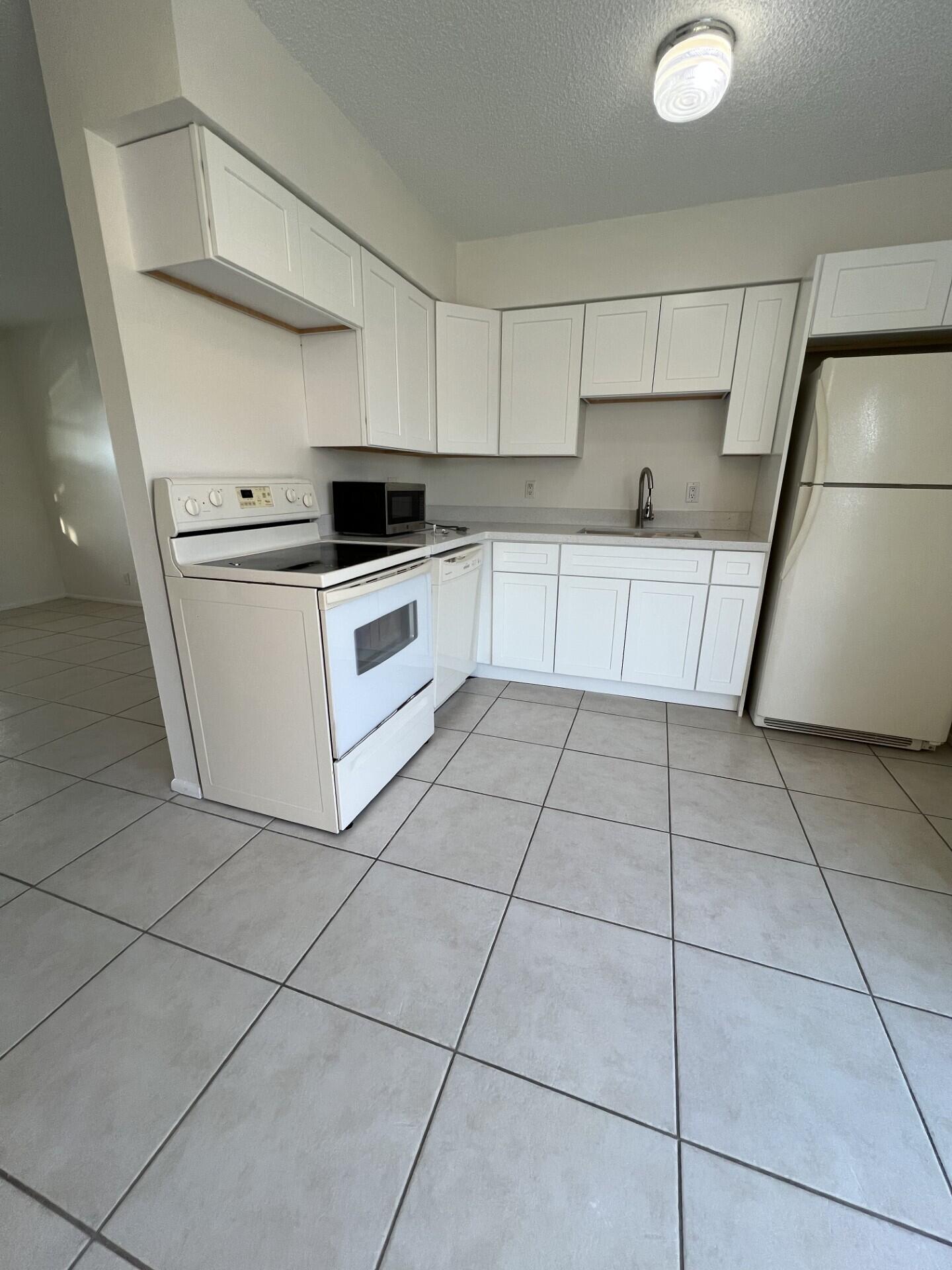 2845 Duke Lane Delray Beach, FL 33445 - Photo 4 of 15 a kitchen with a stove a sink and a refrigerator