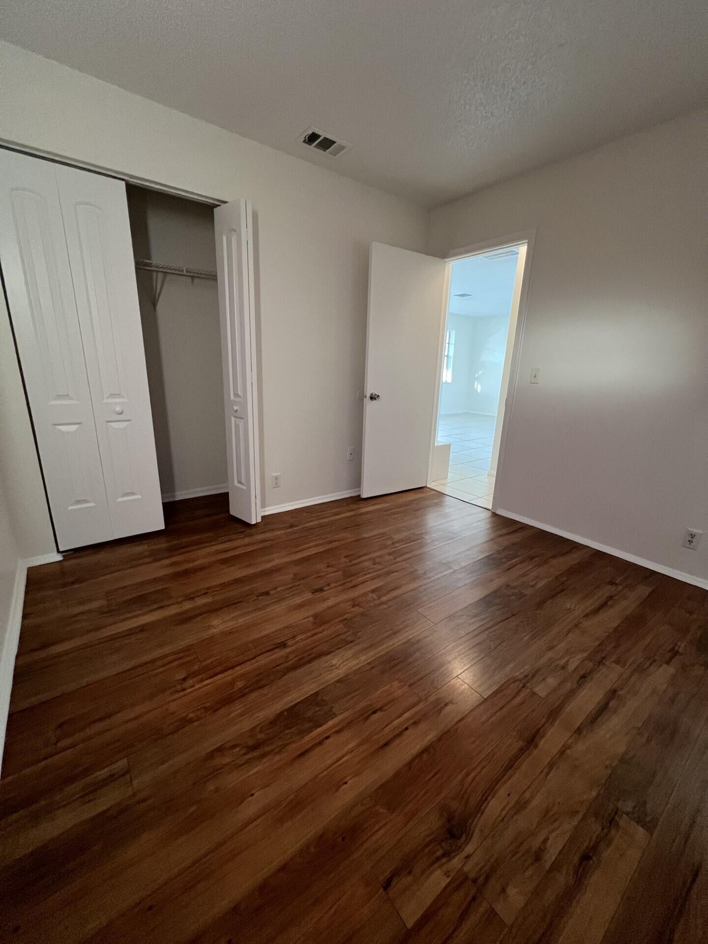 2845 Duke Lane Delray Beach, FL 33445 - Photo 6 of 15 a view of an empty room with wooden floor and closet