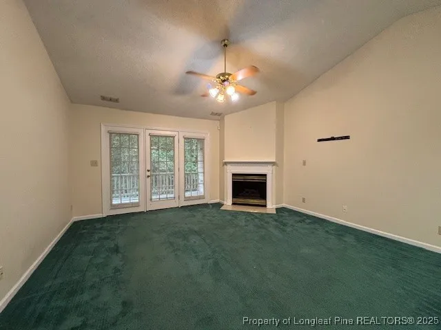an empty room with a window and ceiling fan