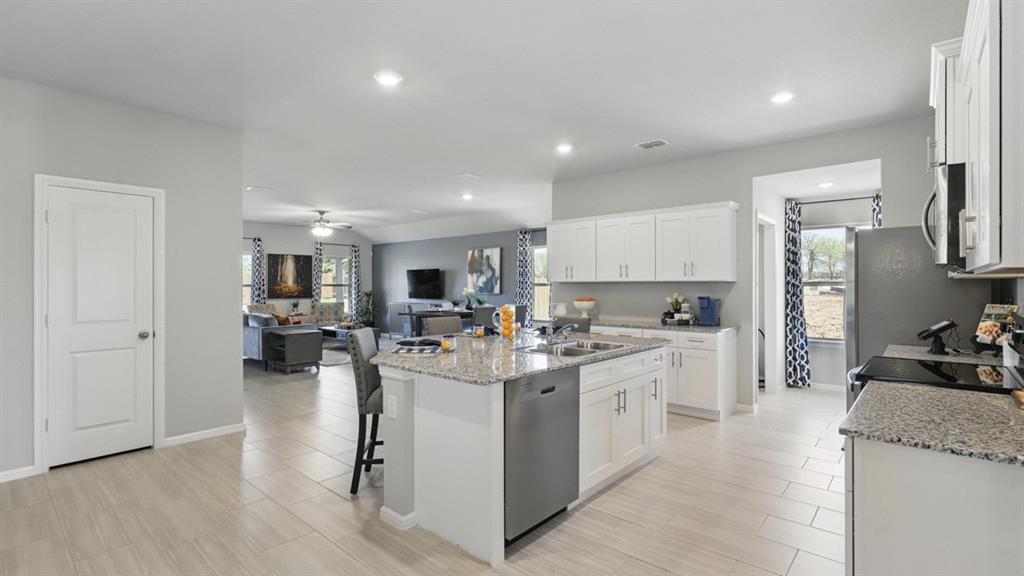 1305 Tin Roof Road Krum, TX 76249 - Photo 2 of 35 a kitchen with a sink stove and cabinets