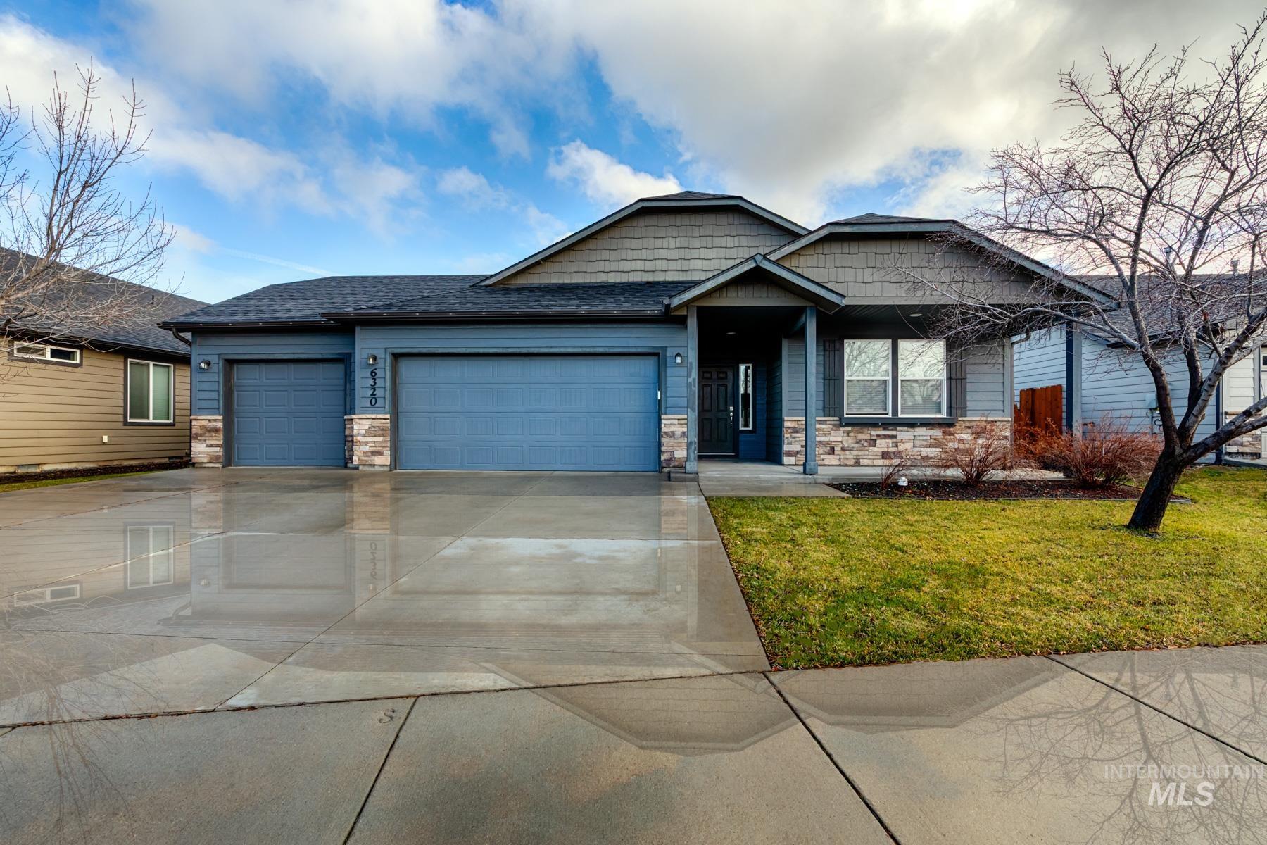 Craftsman inspired home featuring stone siding, a front lawn, an attached garage, driveway, and a shingled roof