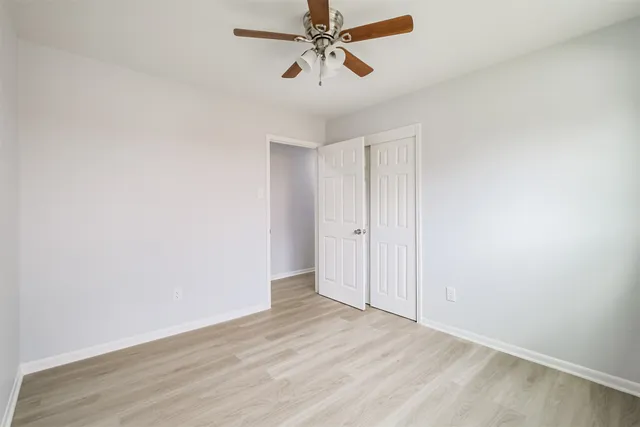 an empty room with chandelier fan