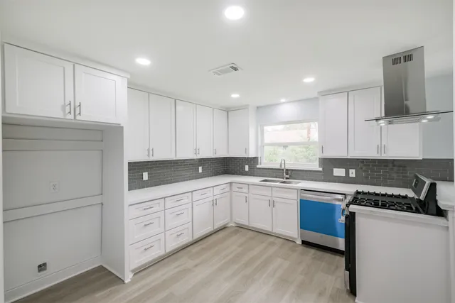 a kitchen with white cabinets sink and white appliances