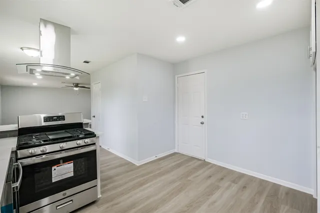 a view of a kitchen with a stove wooden floor and a sink