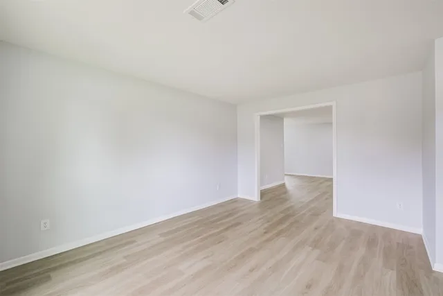a view of an empty room with wooden floor