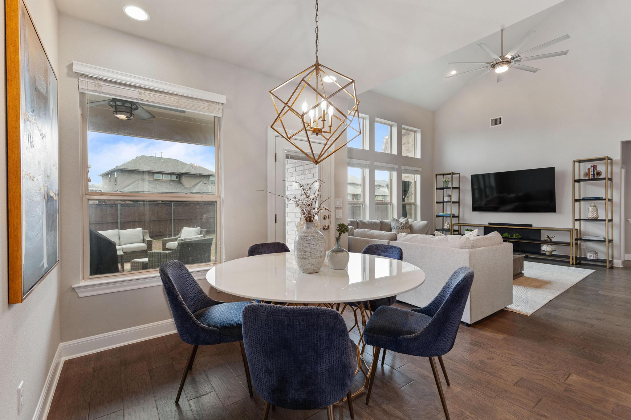 3028 Silvergrass Cove Leander, TX 78641 - Photo 15 of 38 Dining room with a ceiling fan, dark wood-style flooring, a chandelier, and lofted ceiling