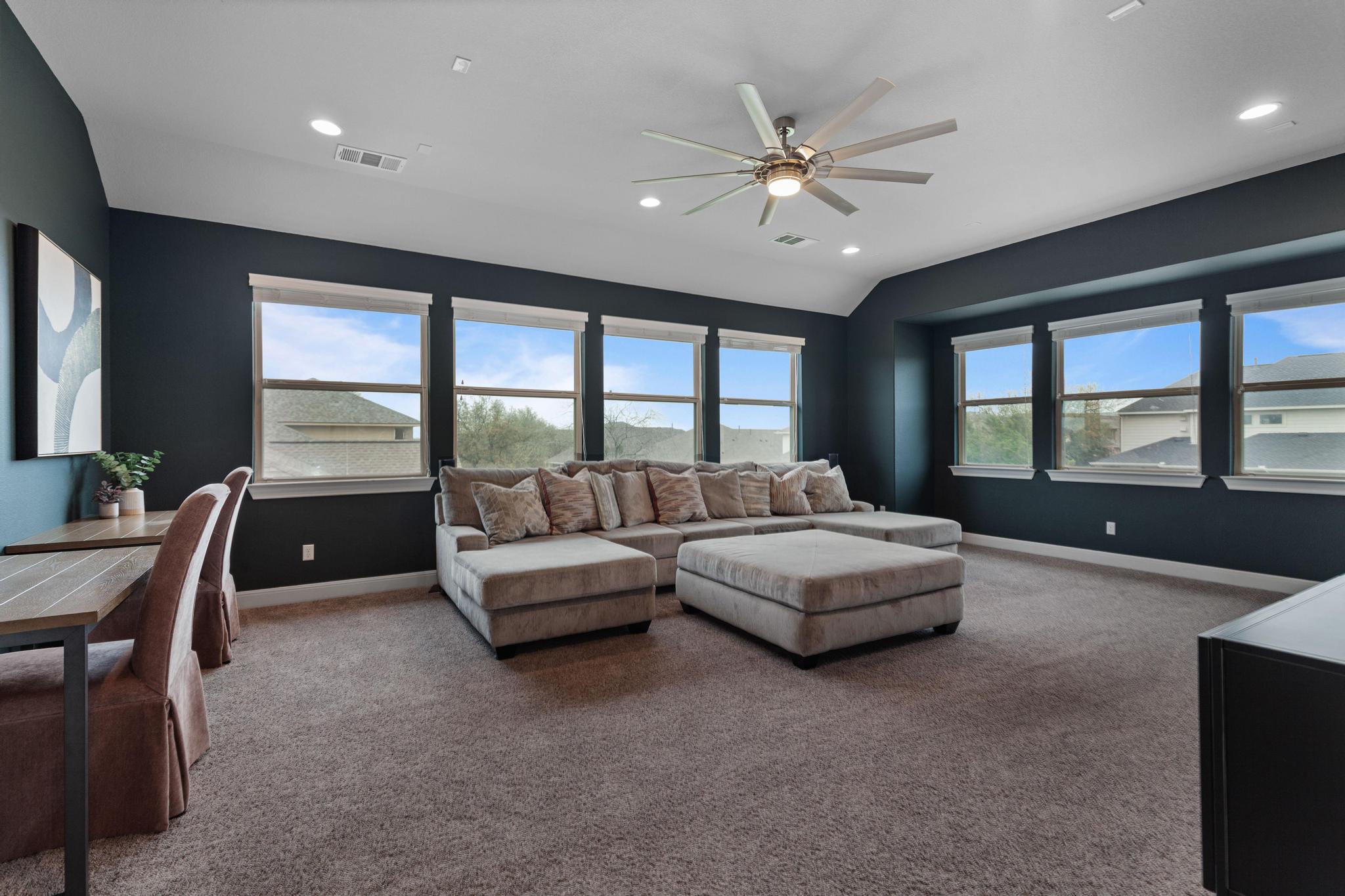 3028 Silvergrass Cove Leander, TX 78641 - Photo 20 of 38 Carpeted living room with a ceiling fan, lofted ceiling, and recessed lighting