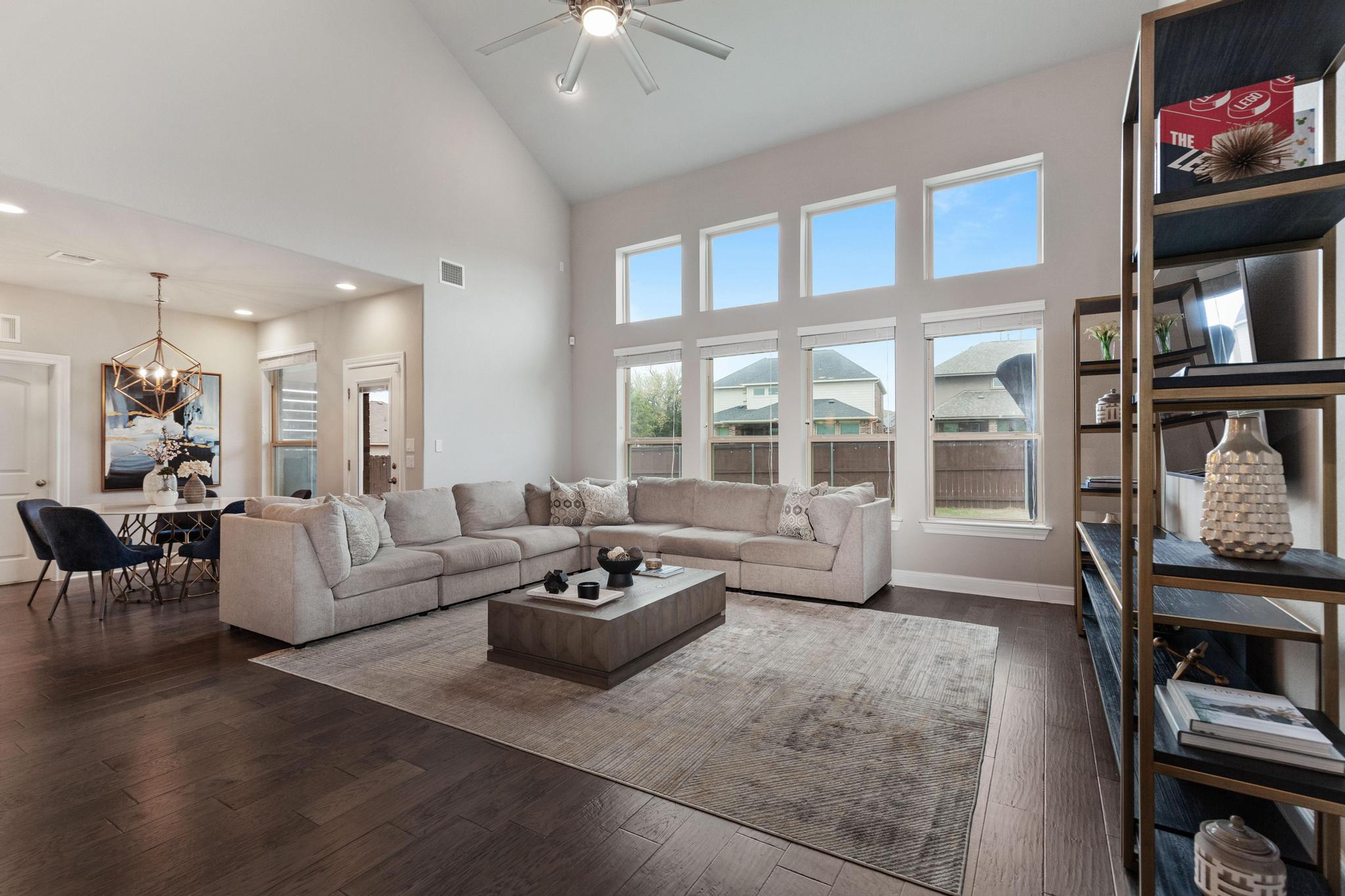 3028 Silvergrass Cove Leander, TX 78641 - Photo 10 of 38 Living room featuring ceiling fan, dark wood-style flooring, suspended lighting, and vaulted ceiling
