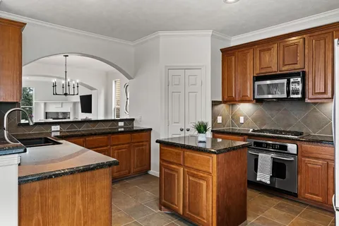 a kitchen with stainless steel appliances granite countertop a stove a sink and a microwave