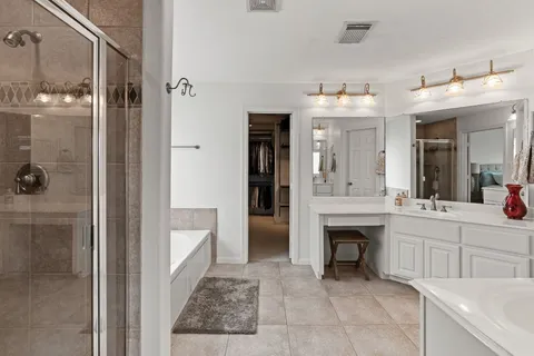 a spacious bathroom with a shower a sink and a mirror