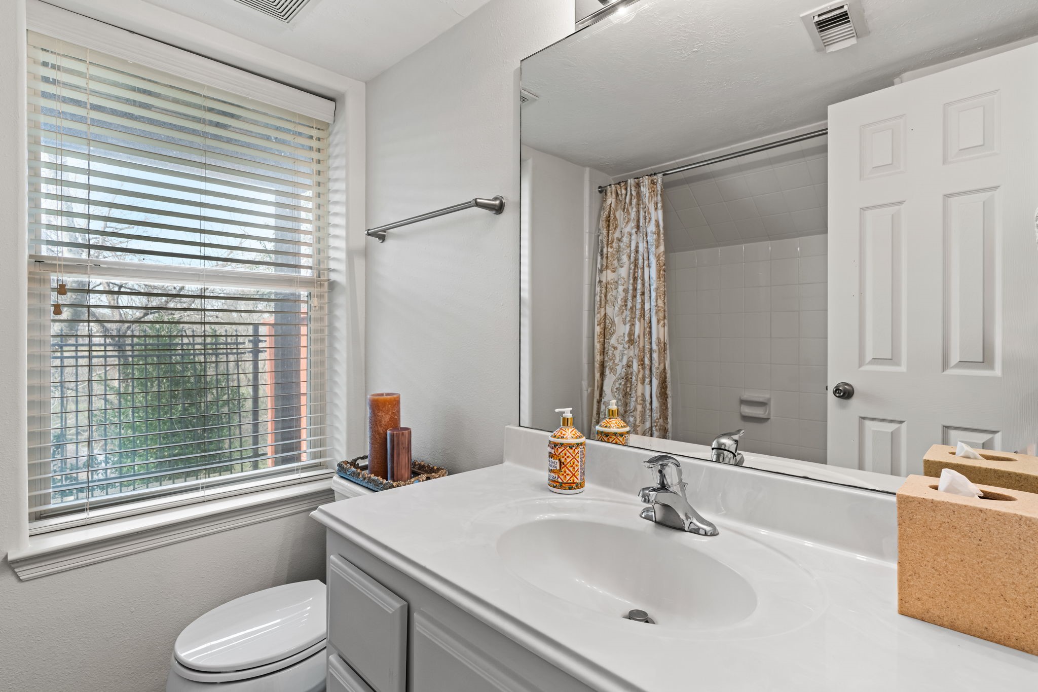 1846 Stacy Crest Houston, TX 77008 - Photo 26 of 32 The first floor bedroom has a bright full ensuite bathroom offering convenience on the lower level. Clean tile surfaces and a spacious vanity make the room both practical and comfortable for daily use or visiting guests.