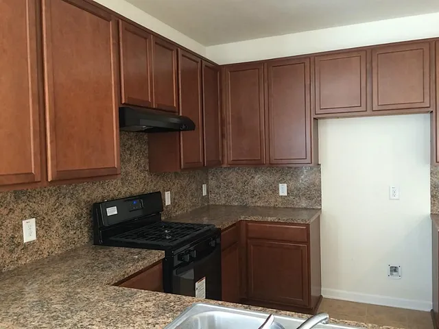 a kitchen with granite countertop cabinets and black appliances