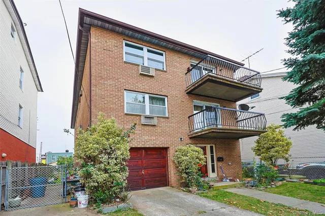 a view of a house with a small yard plants and large tree
