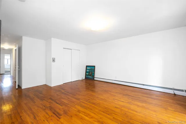 a view of an empty room with wooden floor