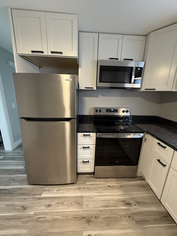 12 Hunnewell Road, Unit 2R Worcester, MA 01606 - Photo 12 of 13 a kitchen with stainless steel appliances granite countertop a refrigerator stove and microwave