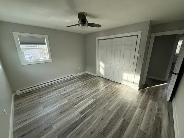 a view of empty room with wooden floor
