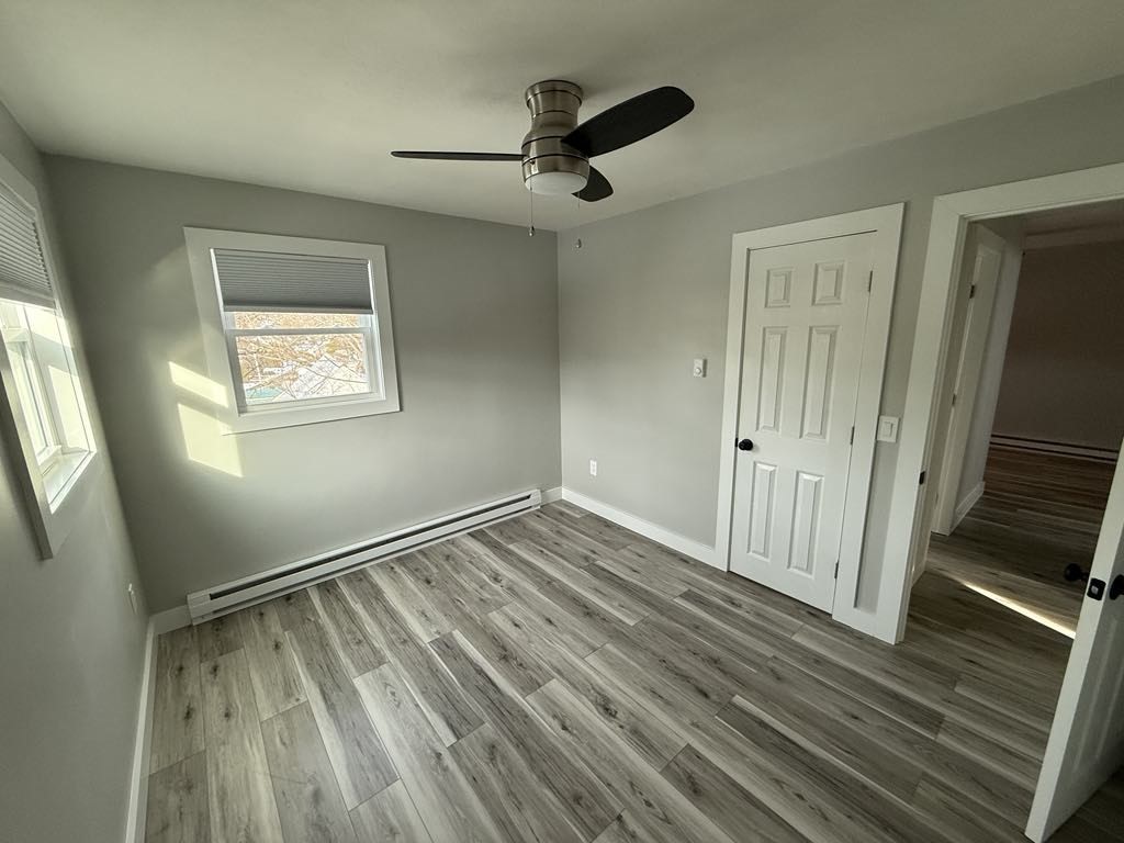 12 Hunnewell Road, Unit 2R Worcester, MA 01606 - Photo 8 of 13 a view of an empty room with wooden floor and a window