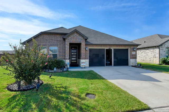 a front view of a house with a garden and yard