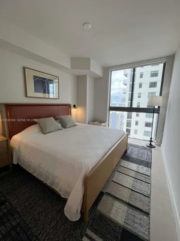 a bedroom with a bed and glass window