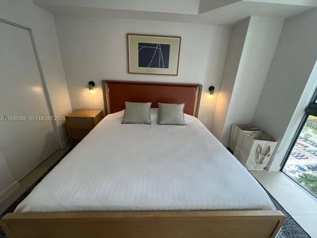 a bed sitting in a bedroom next to a window