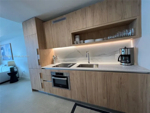 a kitchen with granite countertop a stove and a sink