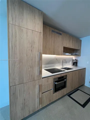a kitchen with cabinets a sink and stainless steel appliances