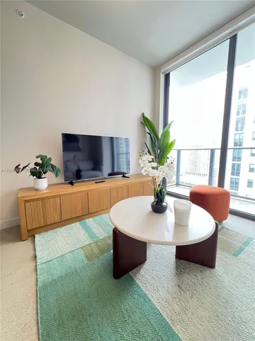 a living room with furniture and a potted plant
