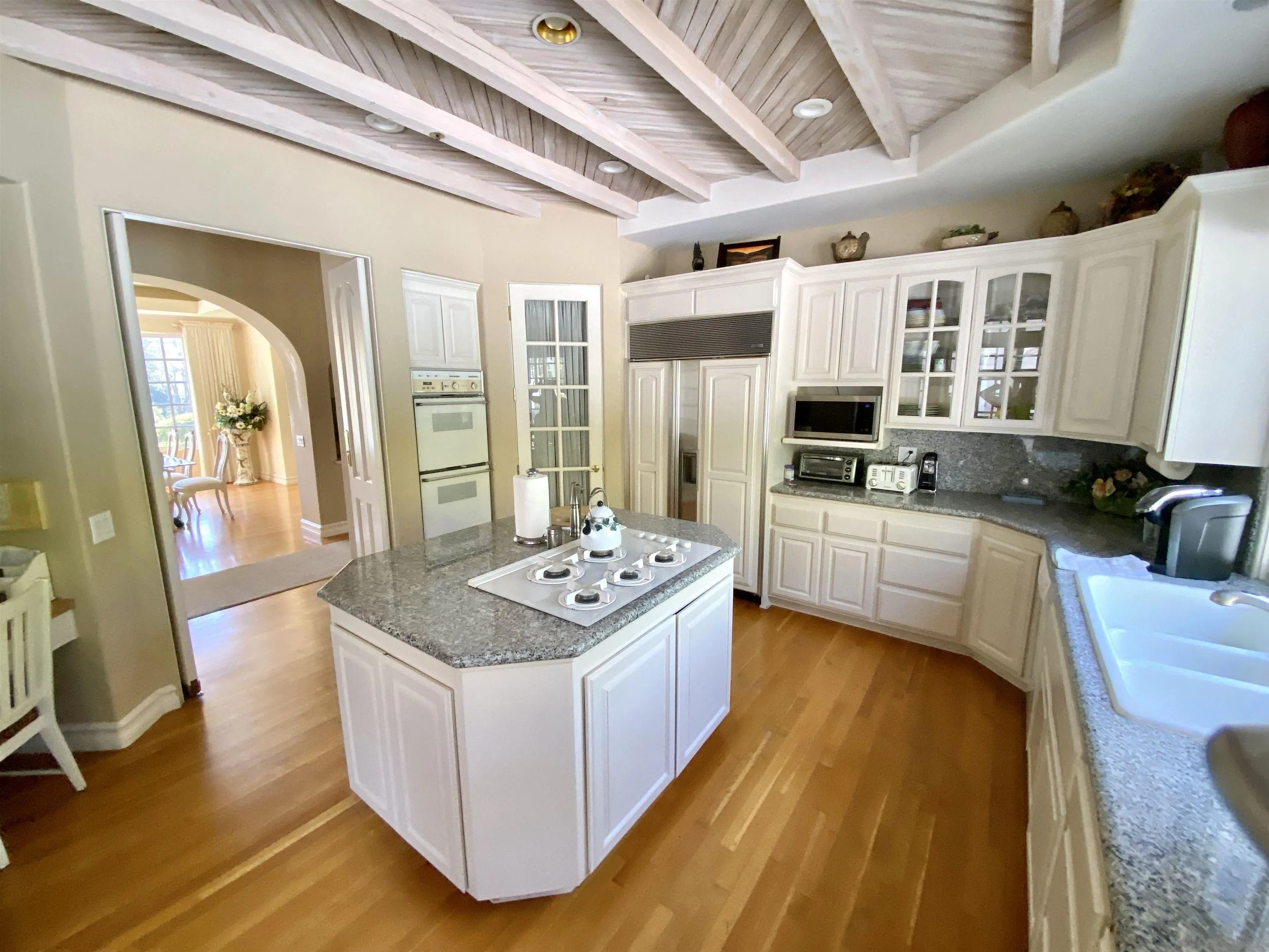 6330 Rancho Diegueno Road Del Mar, CA 92014 - Photo 8 of 22 a kitchen with stainless steel appliances granite countertop a stove a sink dishwasher a refrigerator and white cabinets with wooden floor