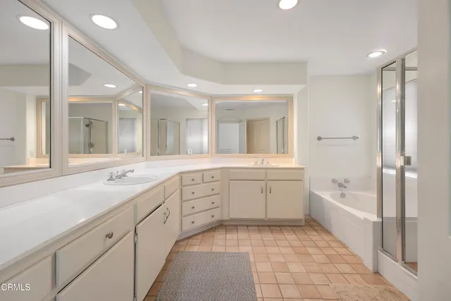 a large bathroom with a sink a large mirror and a bathtub