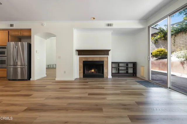 a view of empty room with wooden floor and fireplace