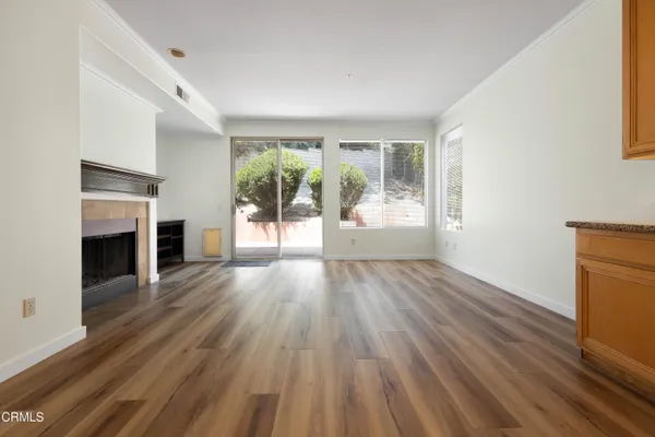 a view of empty room with wooden floor and fireplace