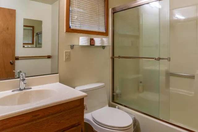 a bathroom with a sink a toilet and shower
