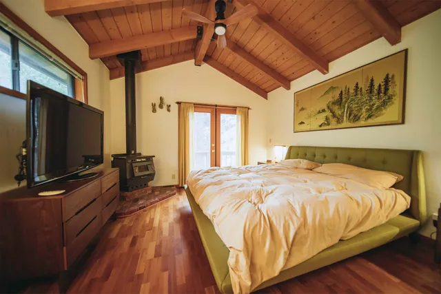 a bed sitting in a bedroom next to a flat screen tv with a dresser