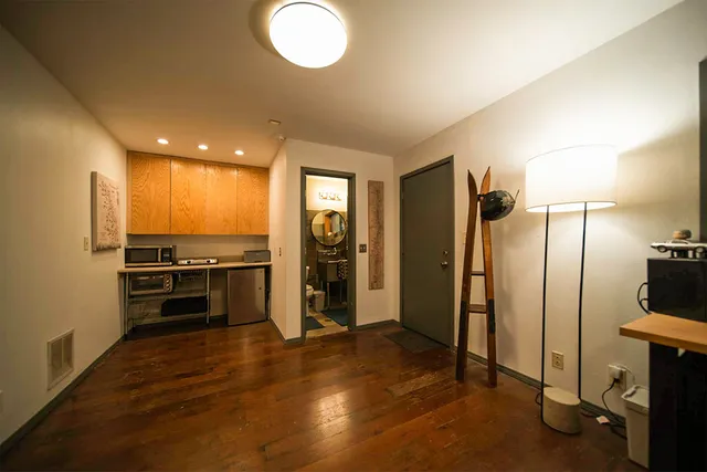 a view of a kitchen with a sink refrigerator and wooden floor