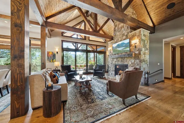 a living room with furniture a large window and wooden floor