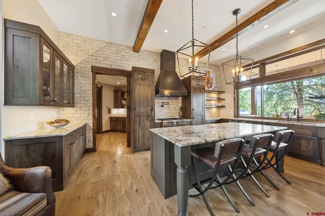 a kitchen with stainless steel appliances granite countertop table chairs and wooden floors