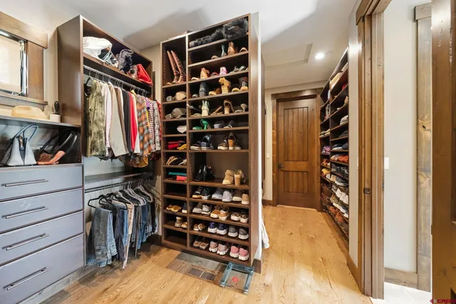 a view of walk in closet with clothes and shoes