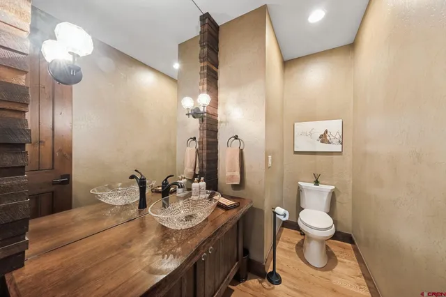 a bathroom with a granite countertop sink a toilet and a mirror