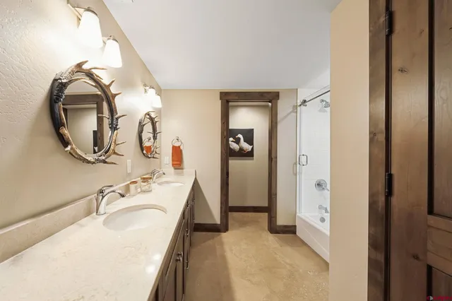 a en suite bathroom with a granite countertop sink mirror and a shower
