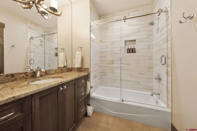 a bathroom with a granite countertop sink a toilet and shower