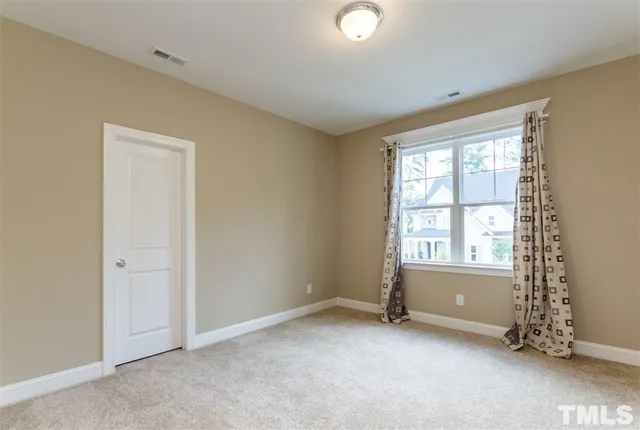 a view of an empty room with a window and a ceiling fan