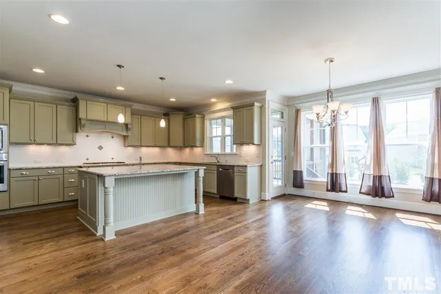 a kitchen with stainless steel appliances granite countertop a refrigerator sink and white cabinets