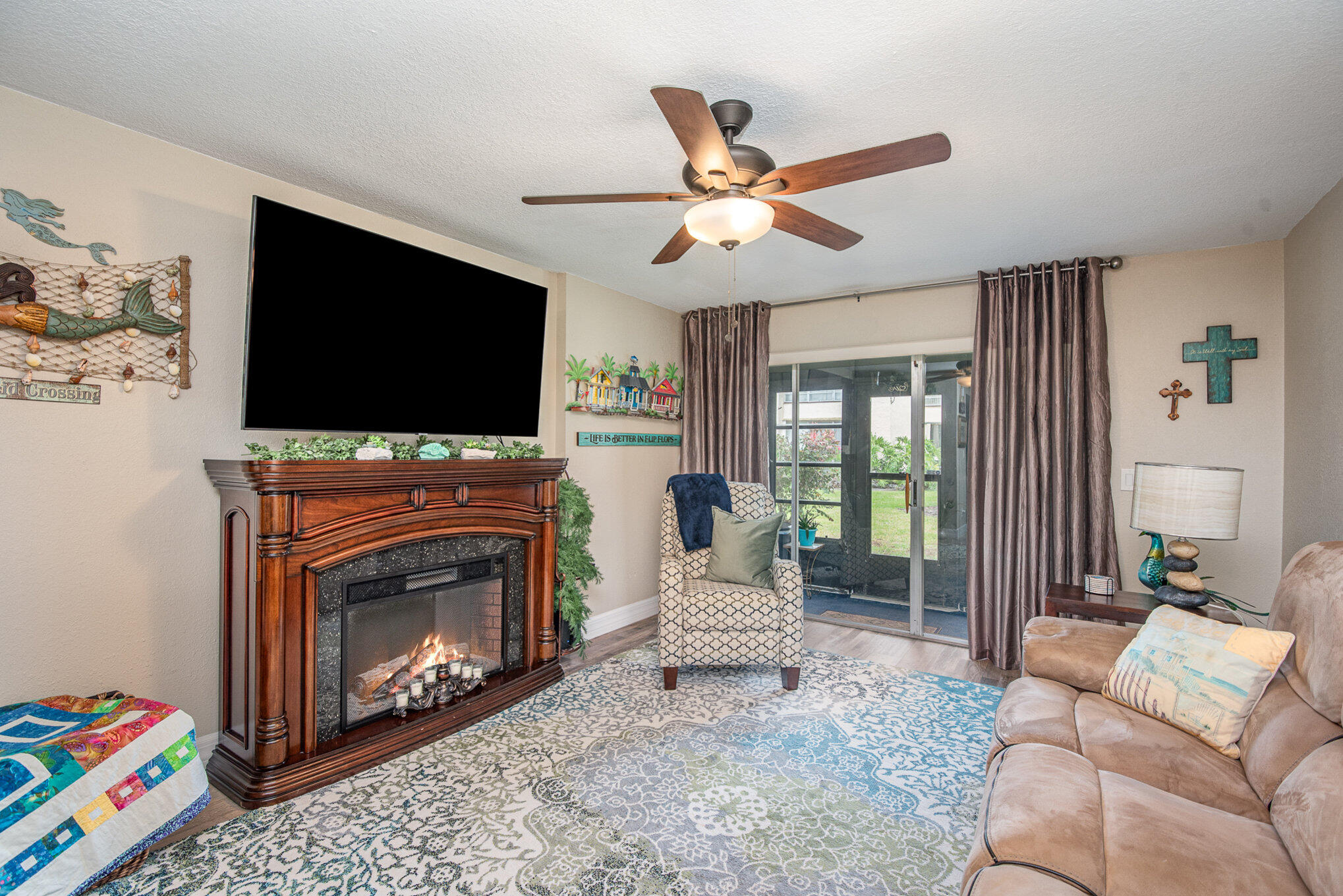2450 Lake Washington Road, Unit 7A Melbourne, FL 32935 - Photo 9 of 24 a living room with furniture a flat screen tv and a fireplace